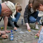 Jugendliche beim Putzen von Stolpersteinen